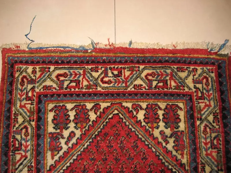 Rug with frayed and worn fringes, needing restoration