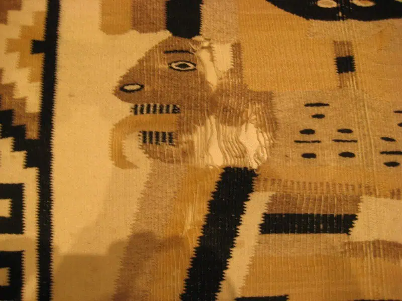Heavily worn Mexican Kilim rug with visible damage before professional restoration