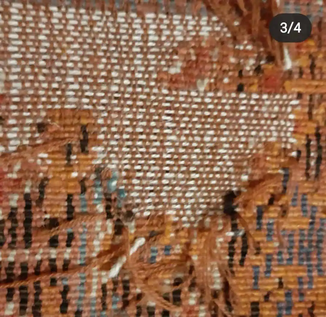 Oriental rug with significant moth damage before professional restoration