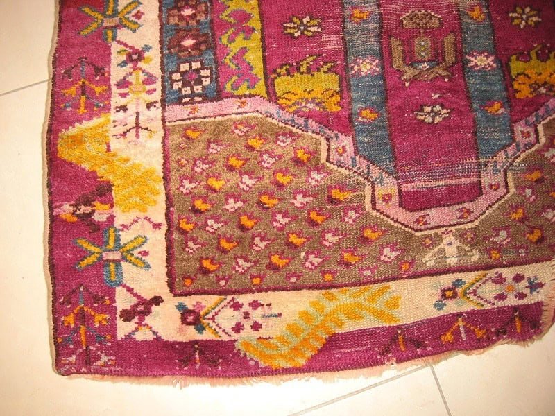 Close-up of a meticulously restored antique Persian rug, showing a seamless repair where a large hole once was