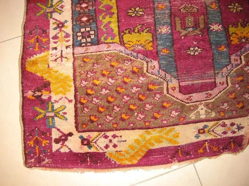 Close-up of a meticulously restored antique Persian rug, showing a seamless repair where a large hole once was