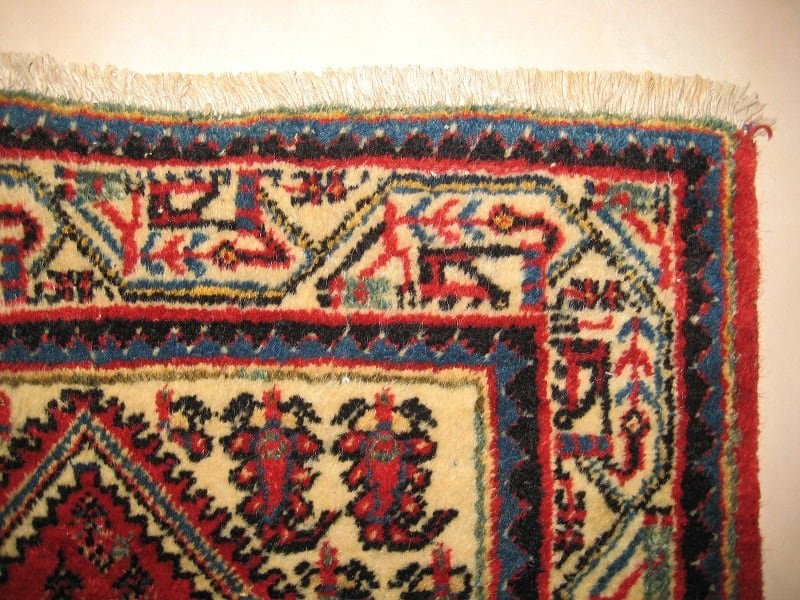 Close-up of a rug's edge with beautifully re-attached and perfectly aligned fringes after restoration.