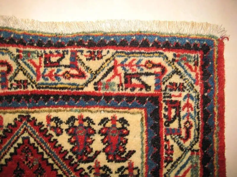 Close-up of a rug's edge with beautifully re-attached and perfectly aligned fringes after restoration.