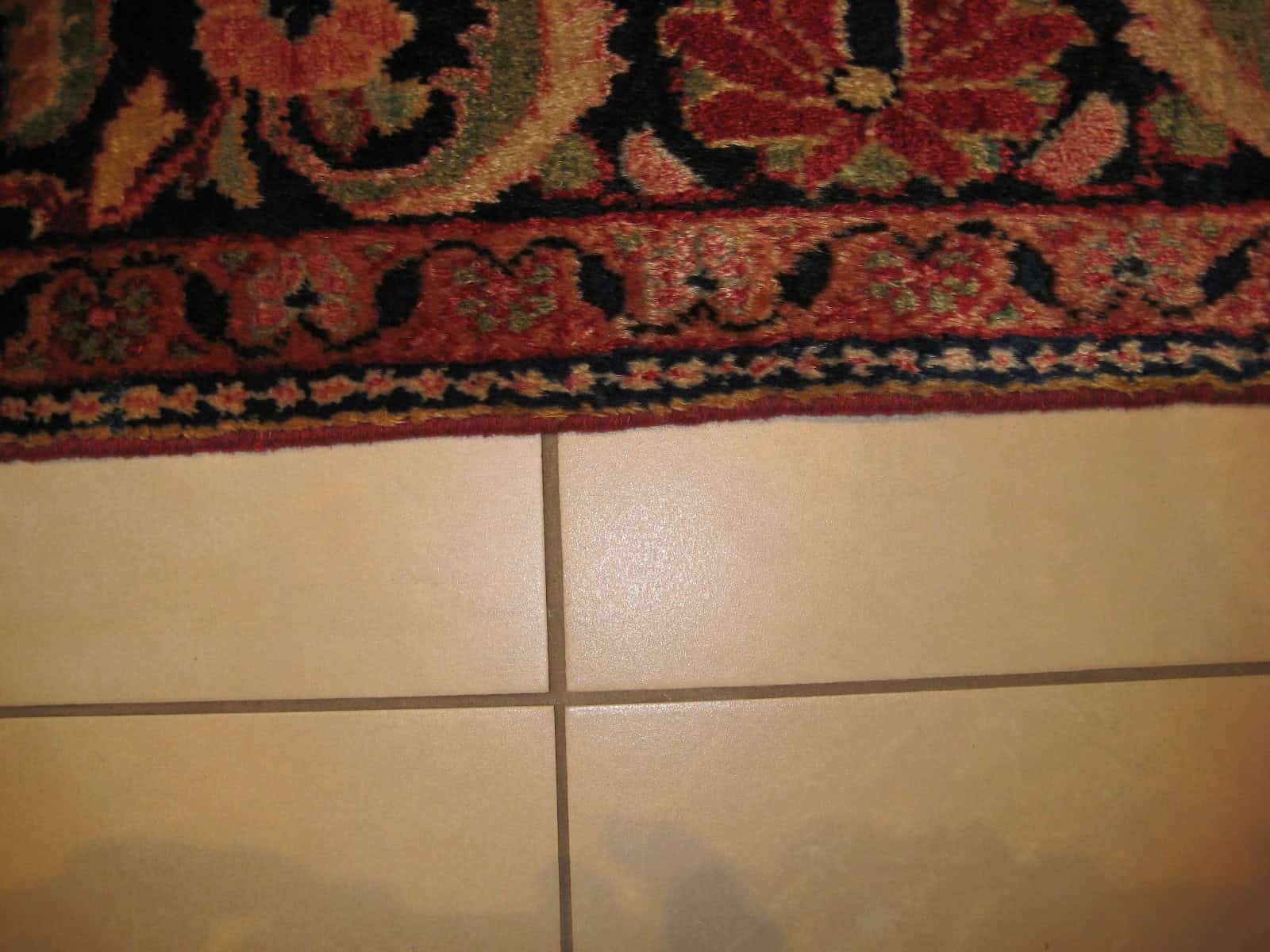 Close-up of an old carpet's side, showing perfectly re-secured and seamless edges after professional restoration.
