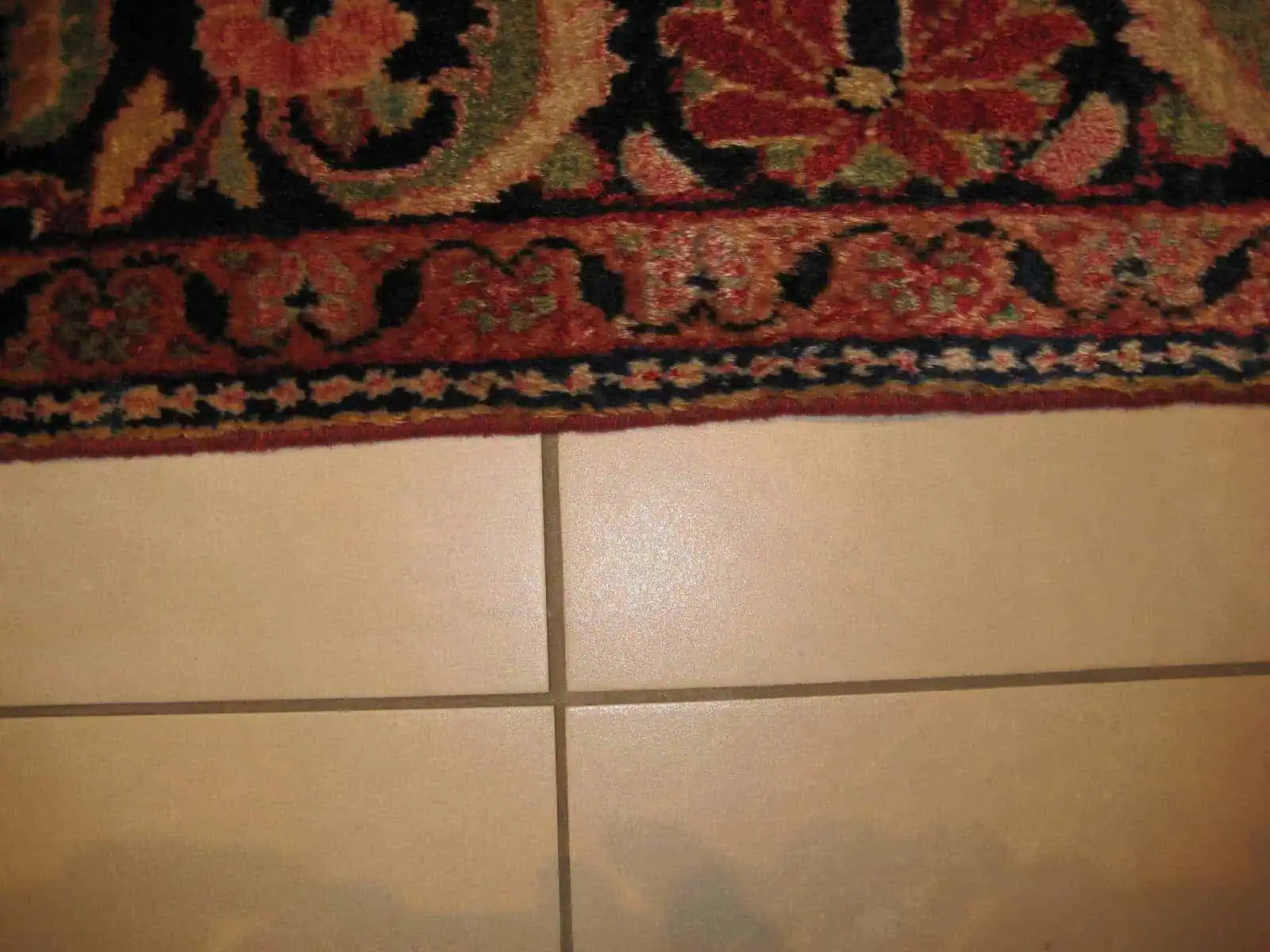 Close-up of an old carpet's side, showing perfectly re-secured and seamless edges after professional restoration.