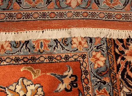 Beautifully restored Persian rug showing no sign of previous hole damage after professional re-weaving.