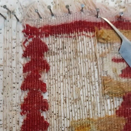 Vintage kilim carpet with visible signs of wear and minor tears, awaiting professional restoration.
