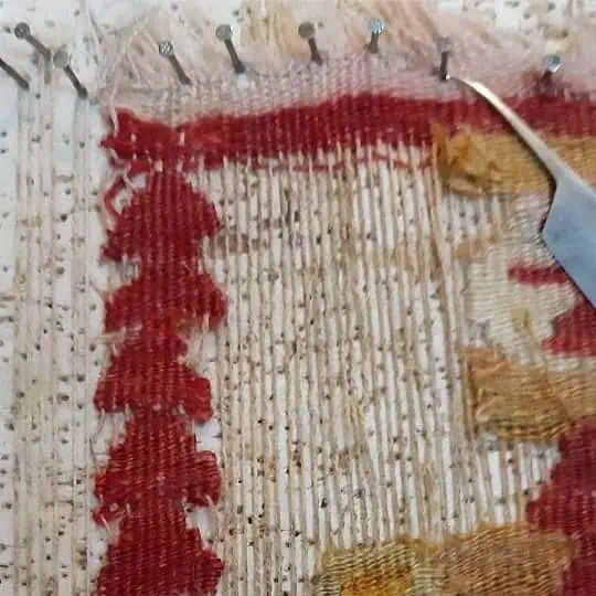 Vintage kilim carpet with visible signs of wear and minor tears, awaiting professional restoration.